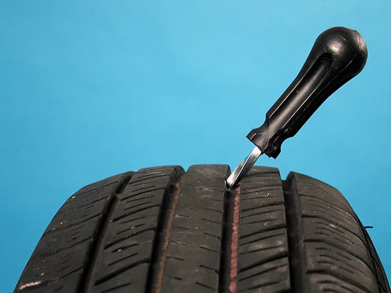 Een reparatieplug wordt in het loopvlak van een band gezet