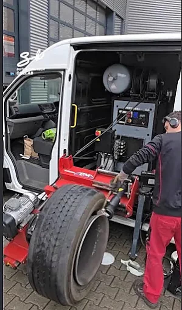 Monteur demonteert een truckband naast de servicebus